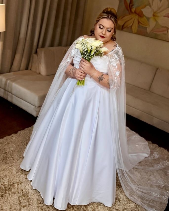 Noiva com vestido, véu e buquê, pronta para o dia do casamento